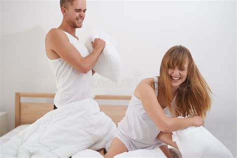 Playful Pillow Fight. a Young Couple Having a Pillow Fight on the Bed