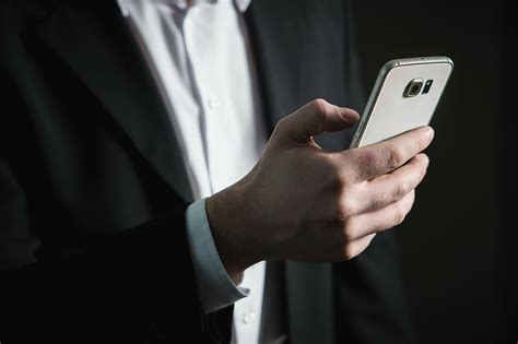 person, black, formal, coat, holding, samsung galaxy android smarpthone ...
