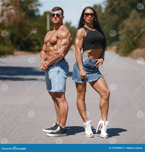 Muscular Couple Outdoors. Sporty Man and Woman Showing Muscles Stock