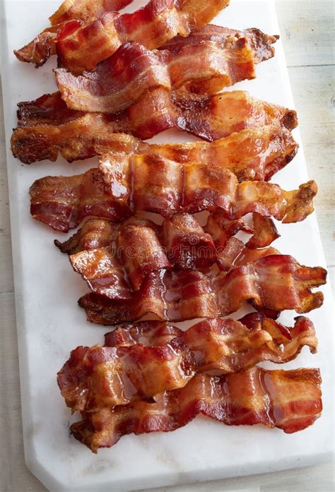 Crispy Strips of Bacon on a White Marble Cutting Board Top View. Stock ...