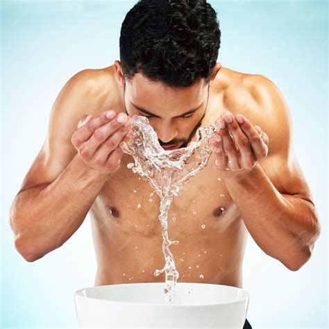 Premium Photo | Water splash studio and man cleaning face in a daily ...
