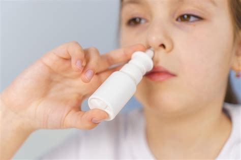 Nariz Escorrendo O Que Tomar - Menina com nariz escorrendo faz irrigações de spray nasal para parar a ...