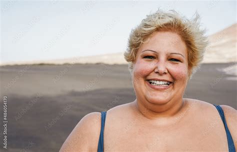 Portrait of curvy woman smiling on camera wearing bikini at the beach