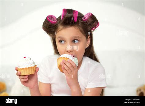 Cute girl eating cupcake Stock Photo - Alamy