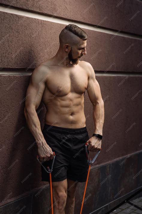 Premium Photo | Muscular man with naked torso with stratching rubber