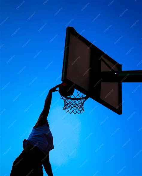 premium photo man dunking  blue sky