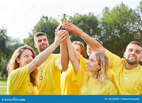 winning team proudly holds  trophy high stock photo image