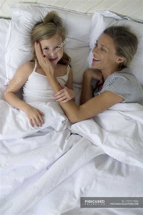 Madre e hija acostadas juntas en la cama — niño, amar - Stock Photo