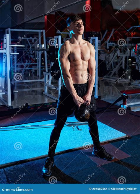 Young Muscular Man with Naked Torso Working Out in Gym. Athletic Male