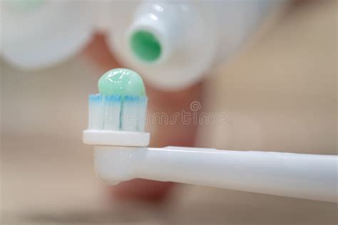 Tube of Toothpaste Pouring Paste on an Electric Toothbrush, Macro ...