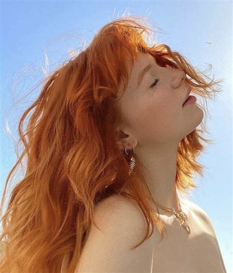 a woman with red hair is looking up into the sky