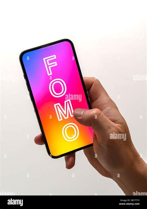 hand holding  smartphone displaying  word fomo fear  missing